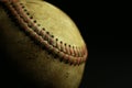 Dirty, old baseball on a black background. Royalty Free Stock Photo
