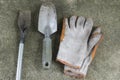Dirty and old garden shovels and gloves on concrete floor.