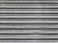 Dirty old grey stained horizontal closed steel rolling security shutters