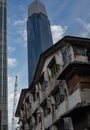 Dirty old residential building apartment n the city over modern skyscrapers and cloudy sky Royalty Free Stock Photo