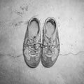 Dirty old shoes on concrete floor Royalty Free Stock Photo