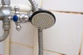 Dirty old shower head with water drops close up with limescale and calcified, rusty shower mixer and mould tiles on Royalty Free Stock Photo