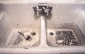 Dirty old white porcelain work sink with dried paint brush sitting in messy crud