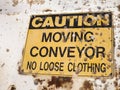 Dirty, old yellow and black Caution - Moving Conveyor No Loose C