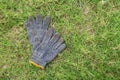 Dirty pair of gloves on green grass outdoor