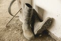 A dirty pair of rubber boots full of dried concrete lies on the unfinished floor of a building under construction Royalty Free Stock Photo