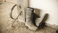 A dirty pair of rubber boots full of dried concrete lies on the unfinished floor of a building under construction Royalty Free Stock Photo