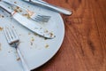 Dirty plate. Empty plate after eating place on wooden table in coffee shop. Royalty Free Stock Photo