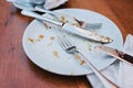 Dirty plate. Empty plate after eating place on wooden table in coffee shop. Royalty Free Stock Photo