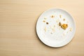 Dirty plate with food leftovers on wooden background. Space for text