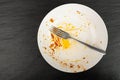 Dirty Plate Top View, Empty Bowl after Dinner, Finished Lunch with Leftover Pasta on Black Plate Background Royalty Free Stock Photo