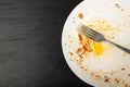 Dirty Plate Top View, Empty Bowl after Dinner, Finished Lunch with Leftover Pasta on Black Plate Background Royalty Free Stock Photo