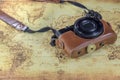 Dirty pocket compact camera on a old world map Royalty Free Stock Photo