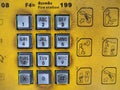 Dirty public telephone silver keypad with yellow background sign instruction