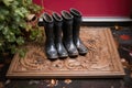 dirty rain boots on a monogrammed door mat Royalty Free Stock Photo