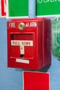 Dirty red fire alarm box with signs on the wall Royalty Free Stock Photo