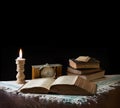 Old bible on the background of a clock and a candle