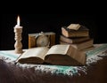 Old bible on the background of a clock and a candle