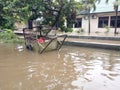 20 February 2021, Dirt Rust Trash Cart submerged in flood at condet East Jakarta, Indonesia while flooding Royalty Free Stock Photo