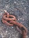 Dirty rusty boat chain lying on the beach sand Royalty Free Stock Photo