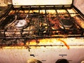 Dirty and rusty top of a kitchen gas stove with pieces of debris, food and burning, dirt stains, used for cooking Royalty Free Stock Photo