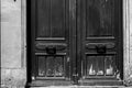 Dirty and scratched bottom part of old wooden gates of ancient stone house. Architectural details of Paris door of old building