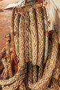 Dirty ship's rope coiled on a rusty iron reel on board a shipwrecked vessel. View from the ship.