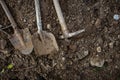 Dirty shovel, pickaxe and spade lying on the ground.