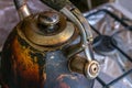 Dirty smoked kettle stands on a gas stove