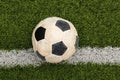 Dirty soccer ball on green football field, top view Royalty Free Stock Photo