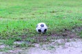 Dirty soccer ball in wet field