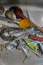 Dirty spoons, forks and a knifes in the sink Royalty Free Stock Photo