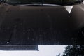 Dirty stained black car, unremovable water stain on car radiator bonnet