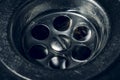 Dirty stainless steel sink drain close up with water drop. Soft focus, toned Royalty Free Stock Photo