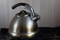 Dirty stainless steel kettle with stains to clean on the stove