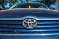 Dirty Toyota logo , visible Wunder Baum air freshener on parking car.