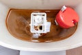 Dirty unhygienic rusty and calcified flush tank of toilet with limescale and rust stains and scum need to be cleaned and repared Royalty Free Stock Photo