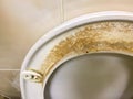 Dirty unhygienic seat of a toilet bowl with limescale stain at public restroom close up Royalty Free Stock Photo