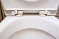 Dirty unhygienic toilet seat close up at public restroom - household and bathroom cleaning concept