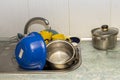 Dirty and unwashed dishes are stacked in the kitchen sink. A mountain of not clean and used tableware.