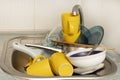 Dirty and unwashed dishes are stacked in the kitchen sink. A mountain of not clean and used tableware.