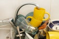 Dirty and unwashed dishes are stacked in the kitchen sink. A mountain of not clean and used tableware.