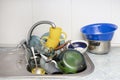 Dirty and unwashed dishes are stacked in the kitchen sink. A mountain of not clean and used tableware.