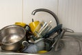 Dirty and unwashed dishes are stacked in the kitchen sink. A mountain of not clean and used tableware.