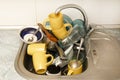 Dirty and unwashed dishes are stacked in the kitchen sink. A mountain of not clean and used tableware.