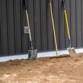 Shovels and rake lean against a wall at a construction site Royalty Free Stock Photo