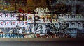 A dirty wall full of graffiti and advertising posters