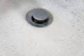 Dirty wash hand basin showing grungy drain with bits of hair Royalty Free Stock Photo