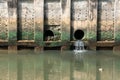 Dirty water flows from a pipe,Sewage pipe polluting water Royalty Free Stock Photo