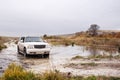 Dirty white SUV crossing the river